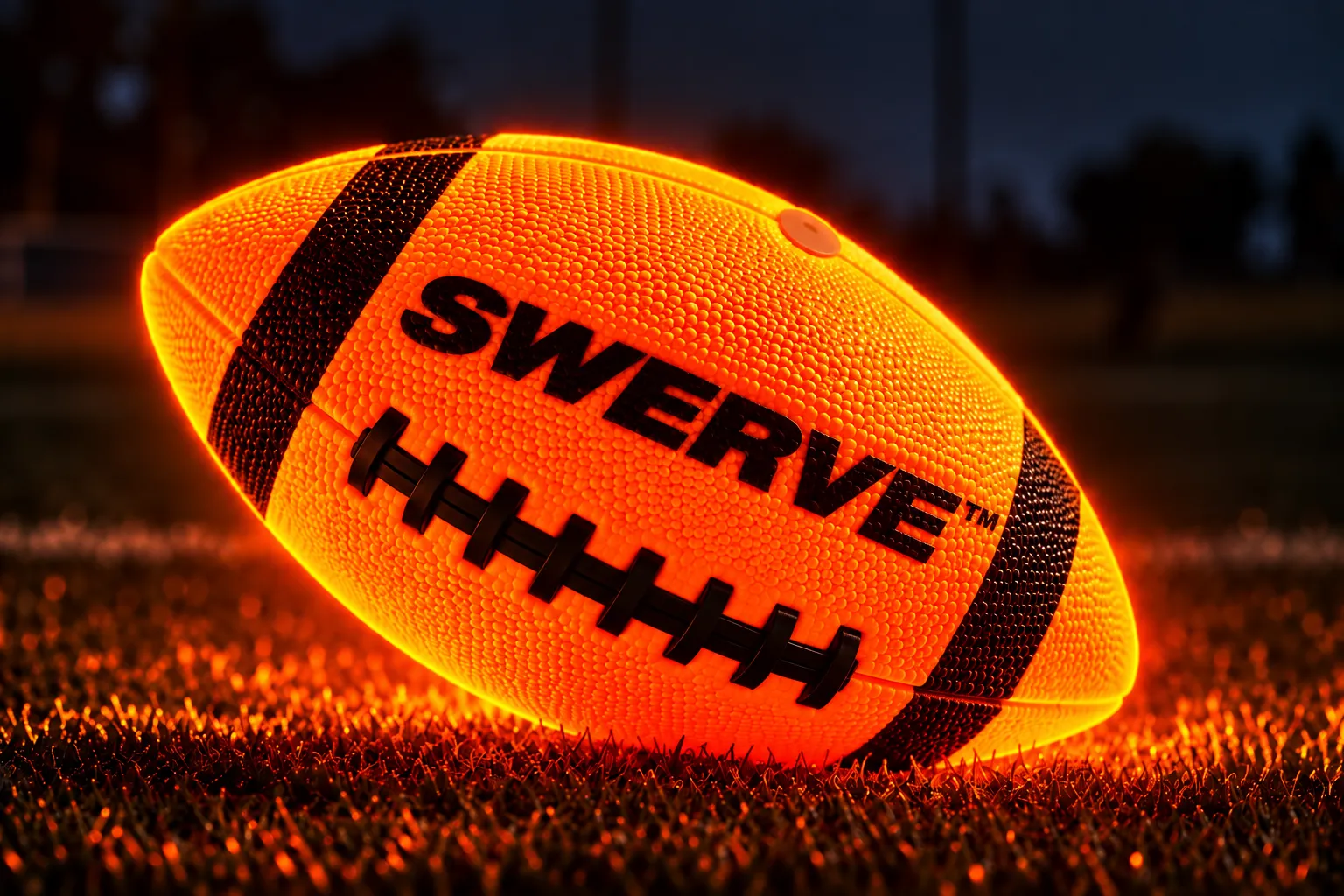 The ember-orange SWERVE American football glowing on turf at night